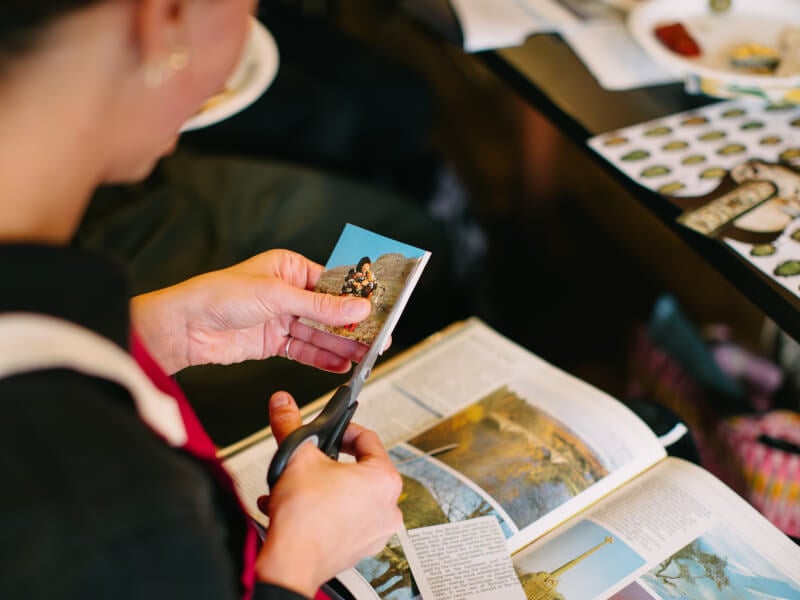 Close up of a person cutting up photographs at a collage workshop